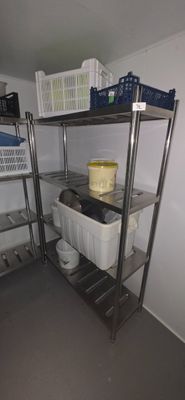 a metal shelf with baskets on it in a room