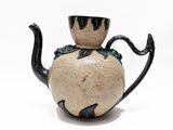 a black and white teapot sitting on a white surface