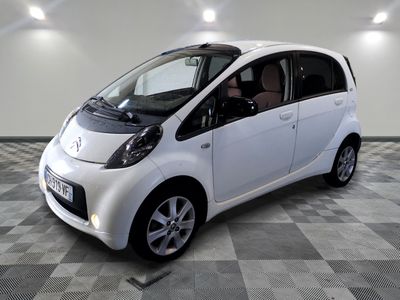 a small white car that is parked in a room
