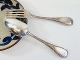 a plate with two forks and a spoon on it