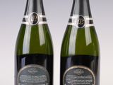 two bottles of champagne sitting next to each other on a table