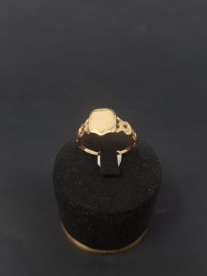 a gold signet ring with a black stone in the middle
