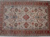 un tapis persan antique avec un motif floral sur fond blanc