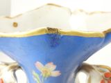 a blue vase that has a gold trim around it