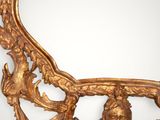 an ornately carved mirror with a gold frame on a white background