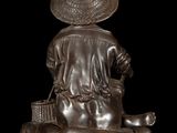 bronze statue of a boy with a basket and a cat
