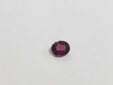 a round shaped pink sapphire stone on a white surface