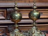 deux vases dorés posés sur une nappe rouge