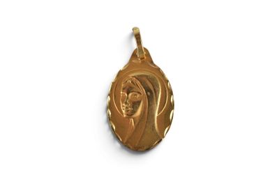a close up of a gold pendant on a white surface