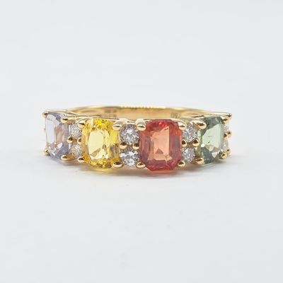 un gros plan sur une bague en or jaune sertie de pierres multicolores