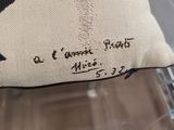 a close up of a pillow with a cross on it sitting on a chair