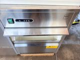 a stainless steel counter top oven with a green towel on it