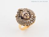 a close up of a gold ring with a face on it