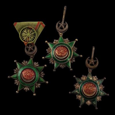 trois pendentifs en forme d'étoile, verts et rouges, sur fond noir
