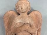 statue of an angel holding a baby in his arms