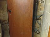 a wooden door in the corner of a room next to a toilet