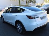 a white tesla model x parked in a parking lot