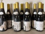 six bottles of wine are lined up in a row on a counter