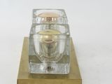 a small glass candle holder on a wooden stand