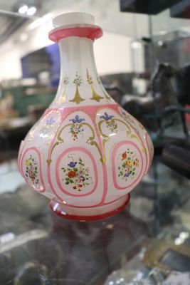 un vase rose et blanc posé sur une table en verre