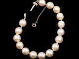 a close up of a pearl necklace on a black background