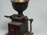 un moulin à café avec un manche en bois posé sur une table