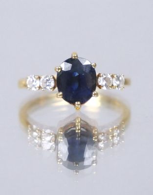 an image of a sapphire and diamond ring on a reflective surface