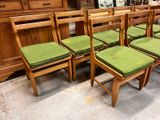 four chairs with green cushions on them in a room