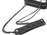 a black bag with a chain attached to it next to a keyboard