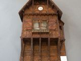 a clock on the wall of a wooden house