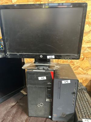 un ordinateur de bureau posé sur un bureau, à côté d'un écran et d'un clavier