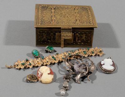 a gold box with a bunch of jewelry on it