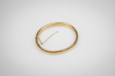 gros plan d'une bague en or sur une surface blanche