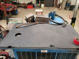 a blue air conditioner sitting on top of a table in a garage