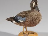 une paire de canards posés sur un socle en bois, sur une surface blanche