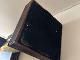 a small wooden object hanging on the wall above a mirror