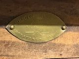 a brass plaque on the side of a wooden box