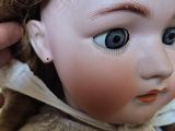 a close up of a doll with a hat on