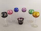 plusieurs verres à vin de différentes couleurs posés sur une table blanche
