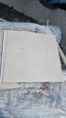 une pile de cartons posée par terre à côté d'une paire de ciseaux et d'une paire de ciseaux