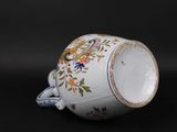 a white cup with a floral design on it on a black surface