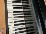 a close up of a piano with a person ' s feet on the floor