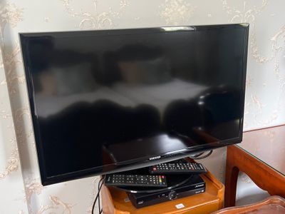 une télévision à écran plat posée sur une table en bois