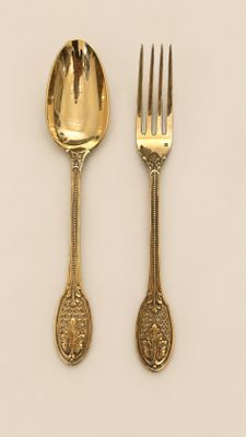 deux cuillères et une fourchette sur une surface blanche