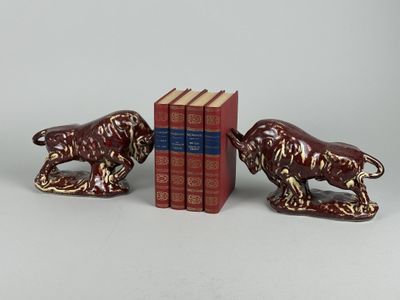 deux figurines de lions et un livre posés sur une table