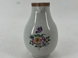 un petit vase blanc orné d'un motif floral