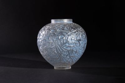 a glass vase that is sitting on a black surface