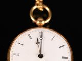 a close up of a gold pocket watch on a black background