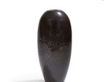 a black vase that is sitting on a white surface