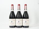trois bouteilles de vin rouge sont posées sur une surface blanche